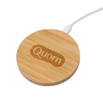 a bamboo circle wireless charger engraved with a Quorn logo 