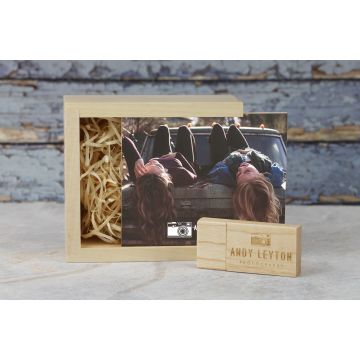 A wooden trinket box printed on the lid with a photo and engraved logo on a Wooden USB next to it 