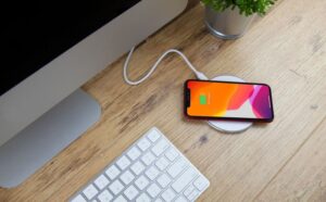 Wireless charger charging an iphone on a desk